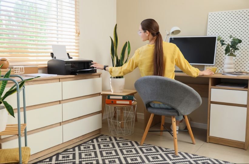 woman using an inkjet printer at a small home office