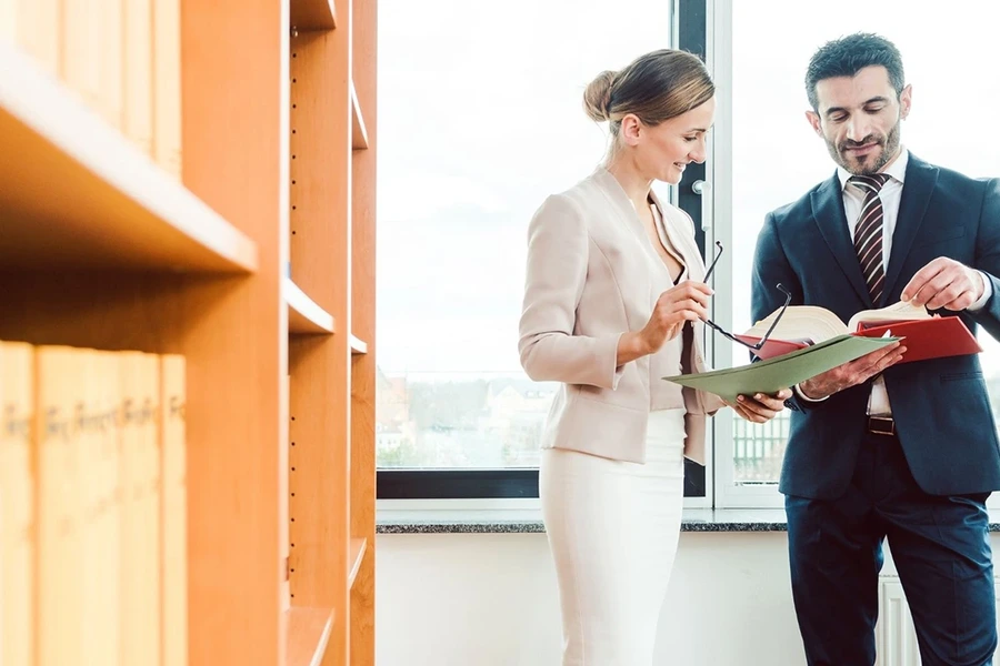 Legal professionals collaborating in front of law bookshelves