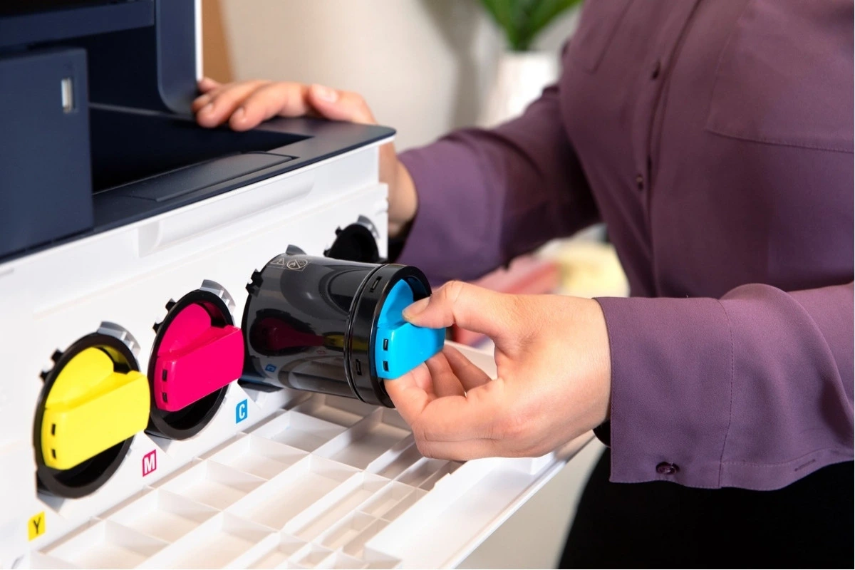 Technician replacing toner cartridge in office printer