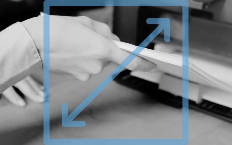 Woman putting paper onto printer