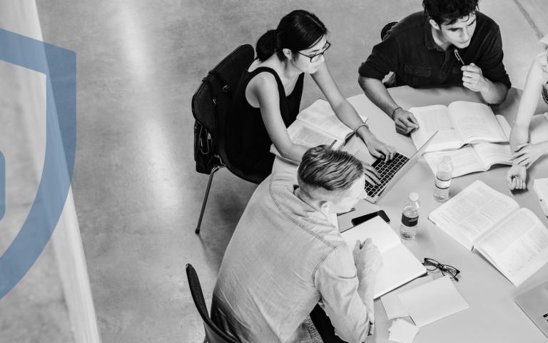A group of students study in a table with a graphic overlay of a safeguard