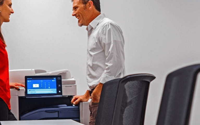 Man and women conversing at the copier.