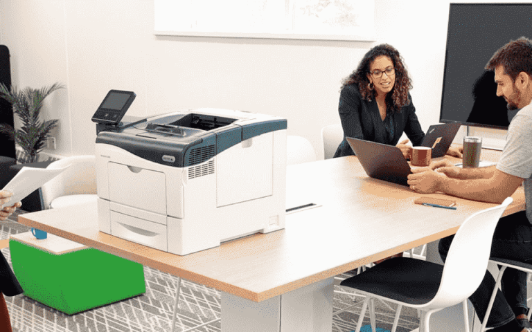 Three people at the office working near a Xerox printer