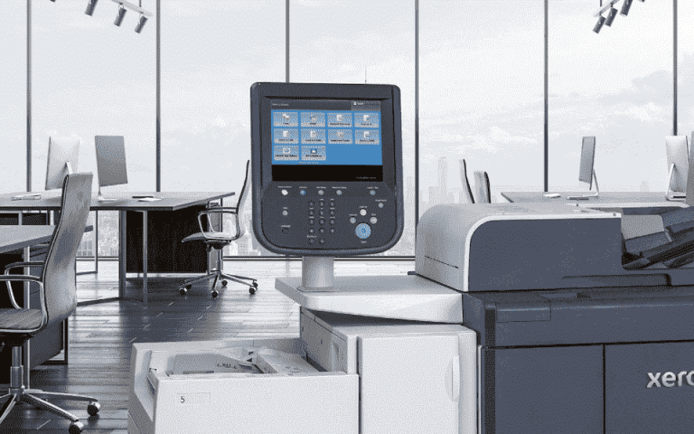 The Xerox PrimeLink B9136 printer in an office with a city view