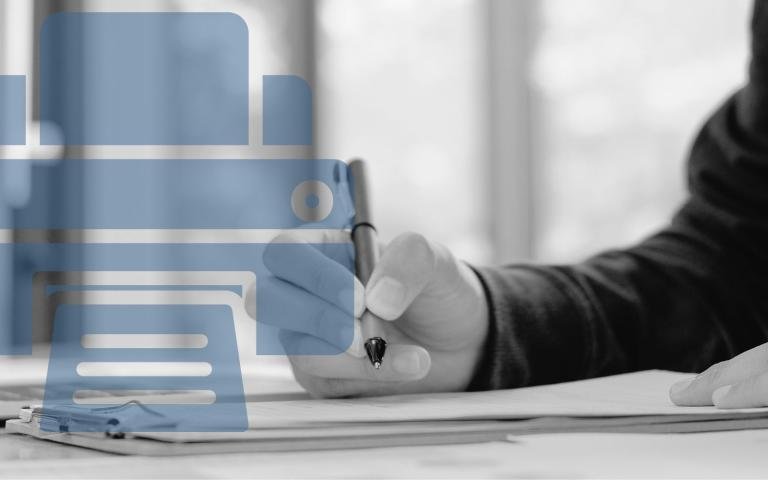 A person filling out a form by a laptop