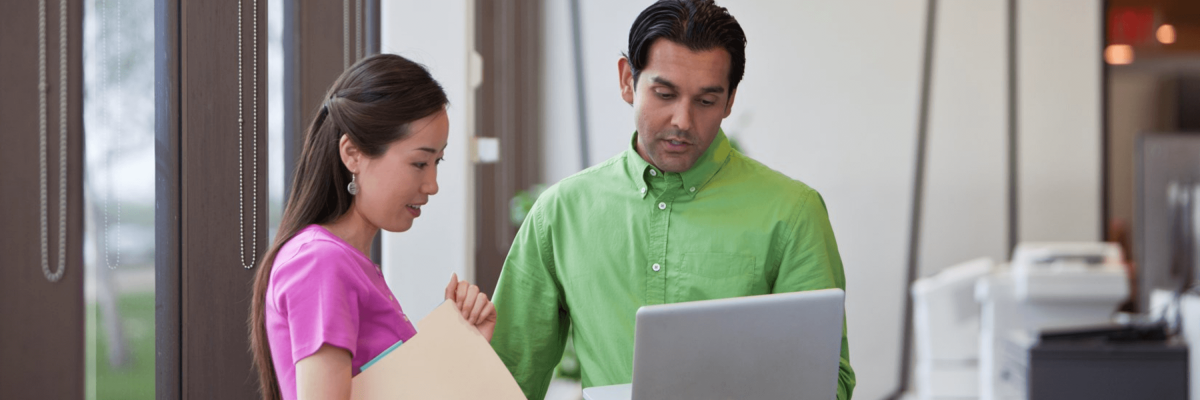 man and woman looking at computer screen
