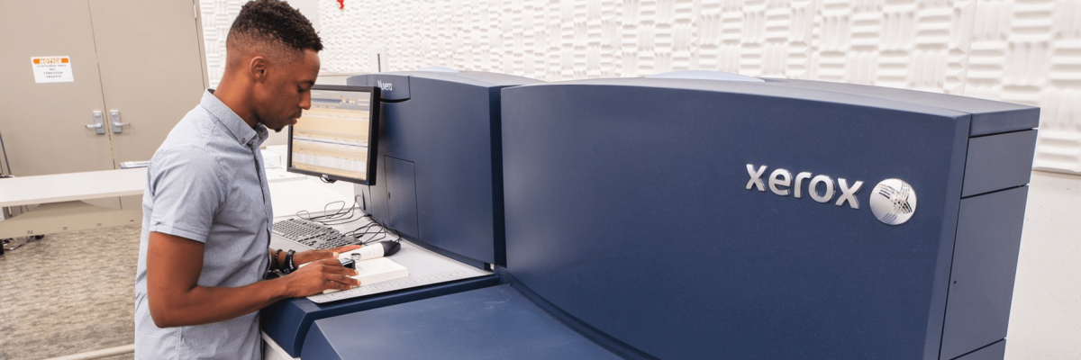 Man at computer next to Xerox machine