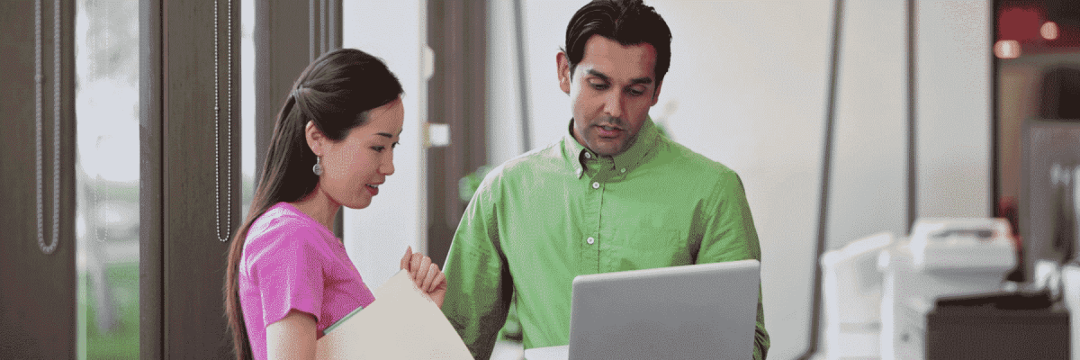 Two people looking at a computer in an office