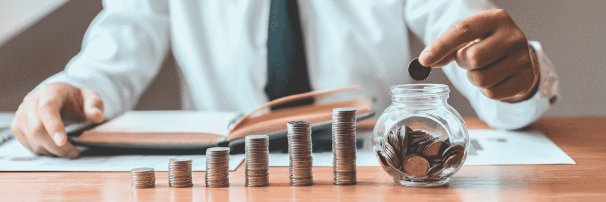 A person organizing coins in rows and putting them in a jar