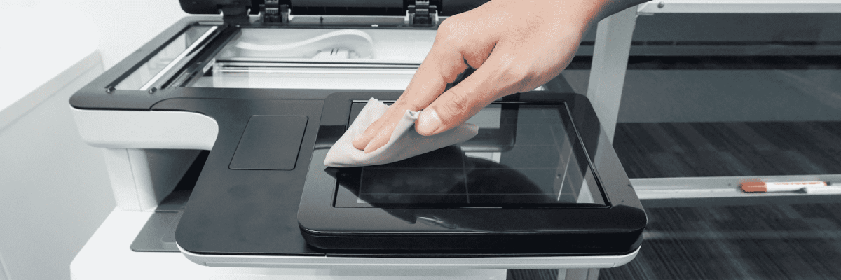 Person using a cloth to clean the glass on a printer