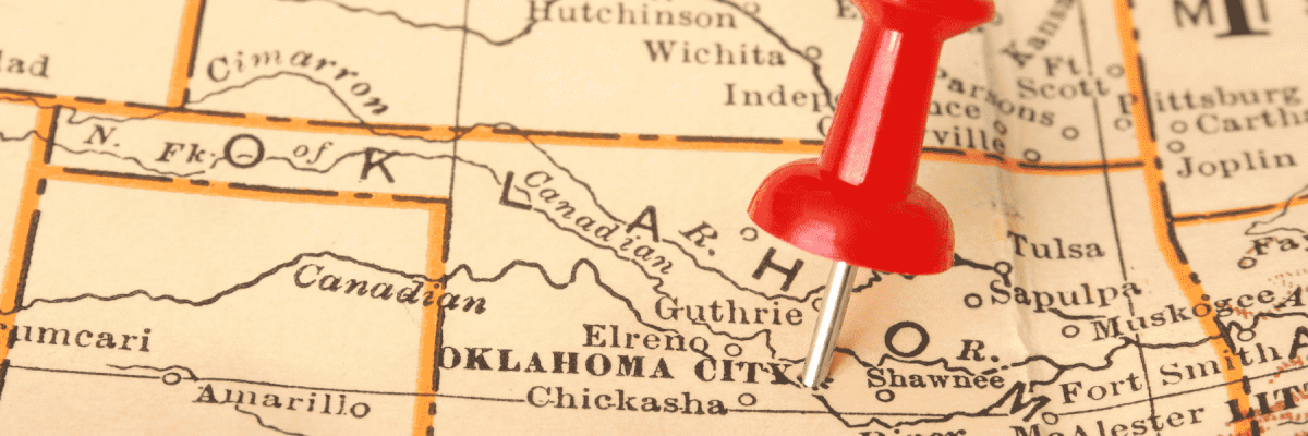 A close up view of a map of Oklahoma with a red thumb tack pinned on Oklahoma City 