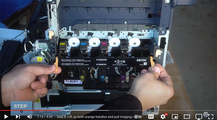 Printer technician lifts both handles on side of imaging unit kit of Xerox VersaLink C410/C415