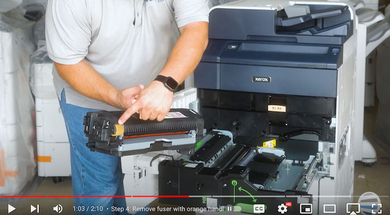 Printer technician shows the white-yellow gear on the fuser assembly on the Xerox PrimeLink C9065/C9070/C60/C70 Printer