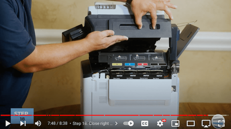 Printer technician closes the top cover on the Xerox C315 printer