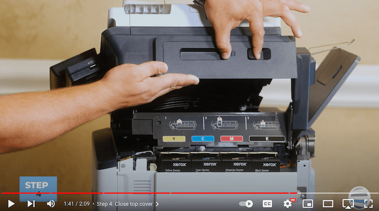 A printer technician closes the top cover on the Xerox C315 Color Multifunction Printer