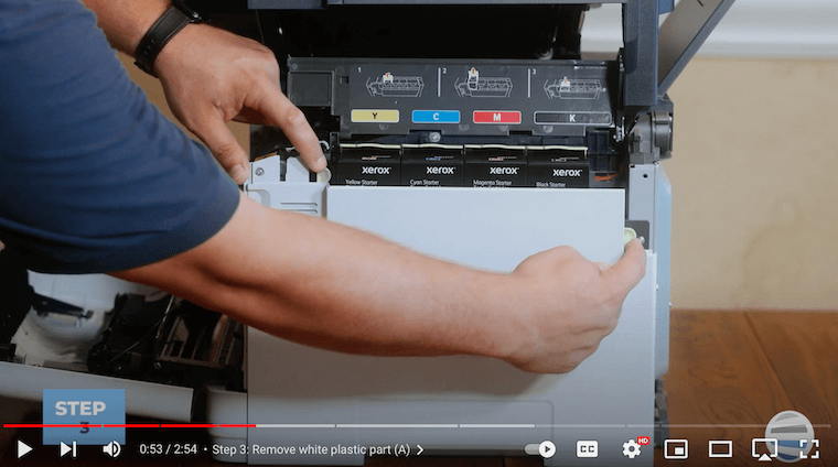 A printer technician removes the white plastic part on the Xerox C315