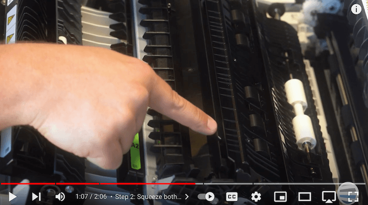 Printer technician opens points out the carrot-shaped protrusion on the Xerox VersaLink C7030