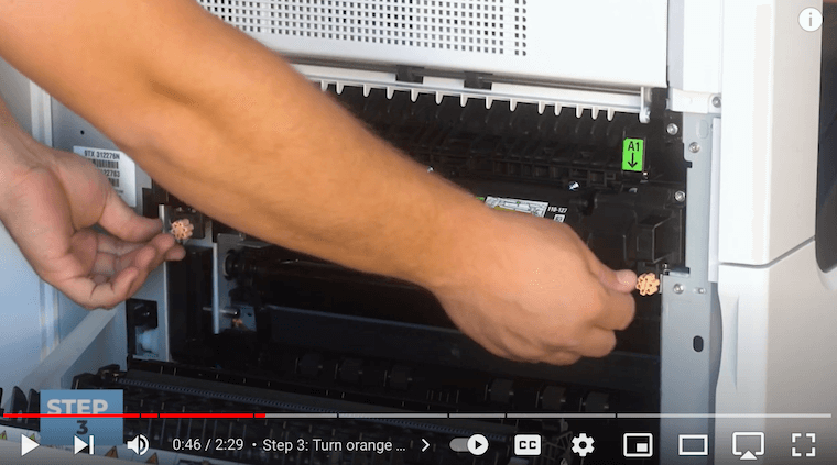 Printer technician turns orange knobs clockwise on the Xerox VersaLink C7020/C7025/C7030 Printer